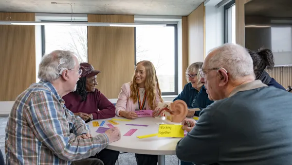 Kate discussing hearing loss and brain health with a group of older people 