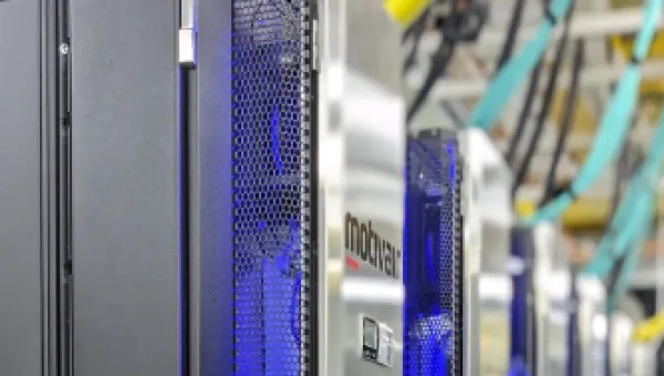 IRIDIS 6 research computing facility - a bank of servers in silver casing with yellow and blue network cables in the background
