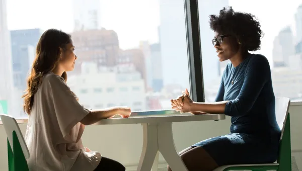 Two women talking at a table