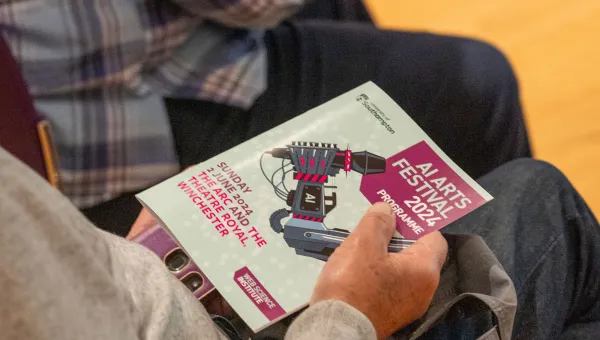 View of the AI Arts Festival magazine in a lap
