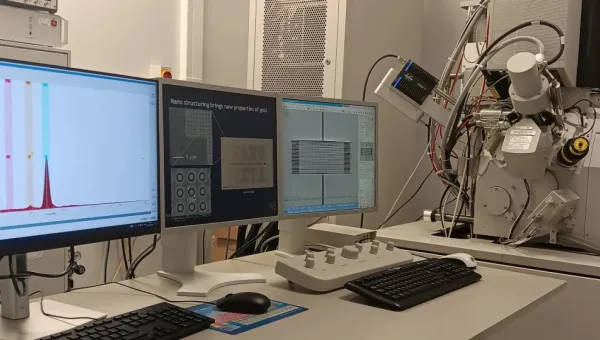 Three monitors and a scanning electron microscope for focused ion beam tool