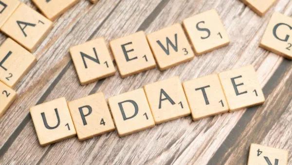 Text reading News Update, made of dominoes letters