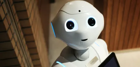 Head and shoulders of a robot with large eyes looking at the camera