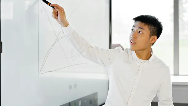 A young man animatedly gestures to a graph