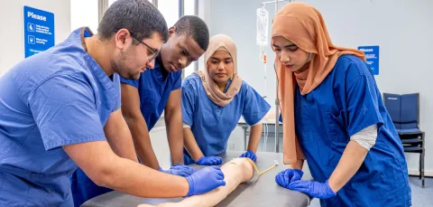 Fahmia and other student doctors studying an arm