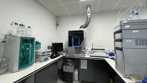 Analytical area at the environmental laboratory with advanced scientific instruments, computer monitor, and exhaust pipe