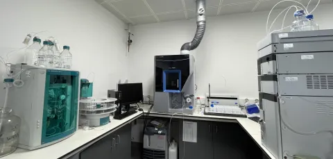 Analytical area at the environmental laboratory with advanced scientific instruments, computer monitor, and exhaust pipe