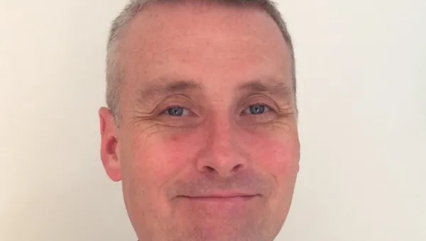 Dr Gary Fuller in a navy button up shirt covered with small white birds.