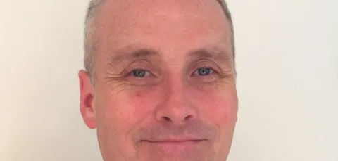 Dr Gary Fuller in a navy button up shirt covered with small white birds.