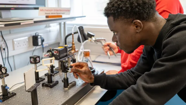 A physics student engaging with lab work