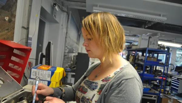 Dr Sarah Moller using tools in a workshop.