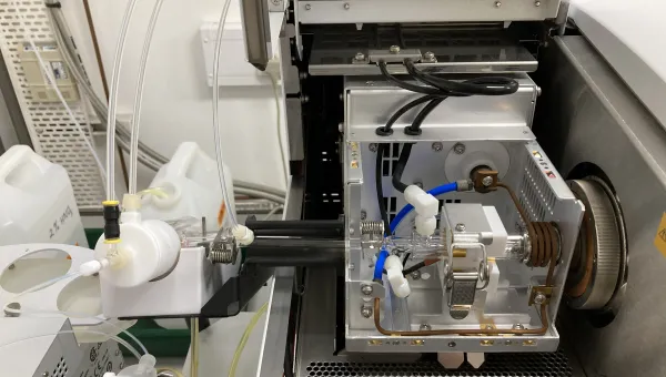 Laboratory instrument with open compartment showing tubes and components.