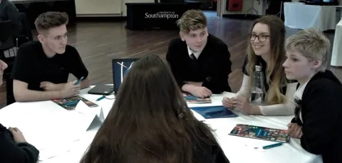 A group of Year 10 students sitting around a table discussing an activity.