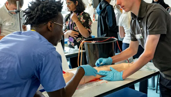 A small group of young people, engaged in a practical medical summer school session to find out what it’s like to be a doctor.