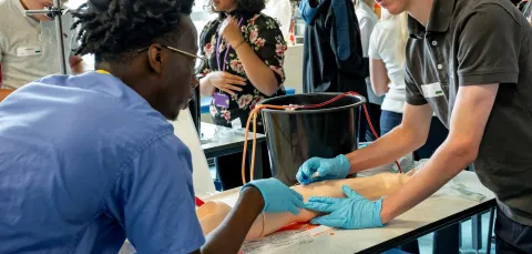 A small group of young people, engaged in a practical medical summer school session to find out what it’s like to be a doctor.