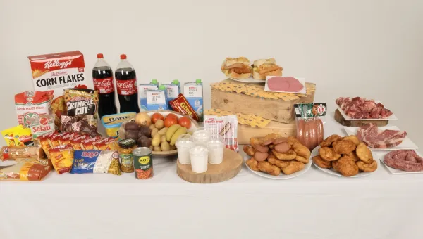A table displaying a wide range of foods, including fresh produce, dairy, packaged snacks, and raw meats.