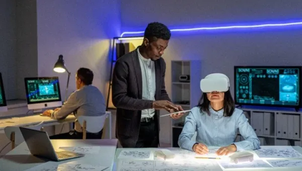 People working in a modern office with virtual reality equipment and computers.