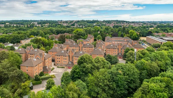 Wessex Lane halls viewed from City Gateway. A cluster of red brick halls surrounded by lush green trees on a sunny day