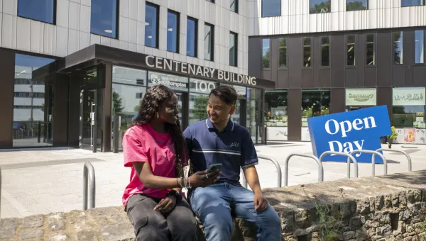 Two students sat outside the Centenary Building on Highfield campus.