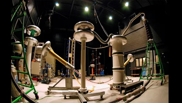 Interior of a high-voltage laboratory showing electrical test equipment, insulators and power cables