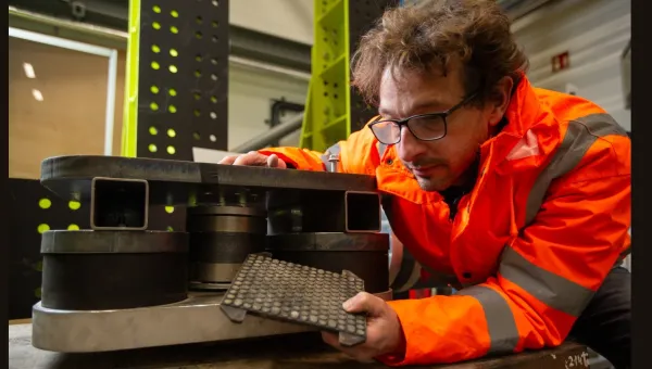 Researcher inspecting a vibration isolation test rig in a laboratory