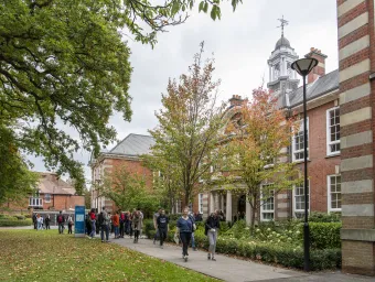 Students outside main building of Avenue Campus on spring day.