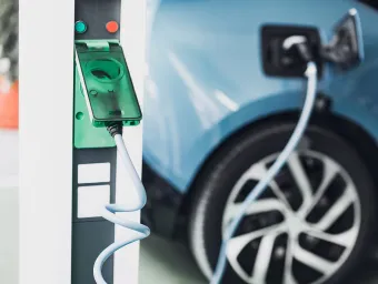 Electric car charging point with car plugged in. 