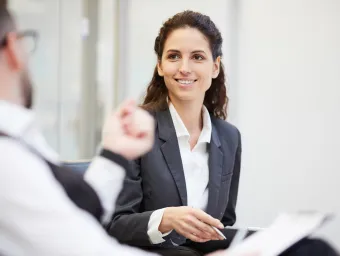 Student in suit talking to academic.