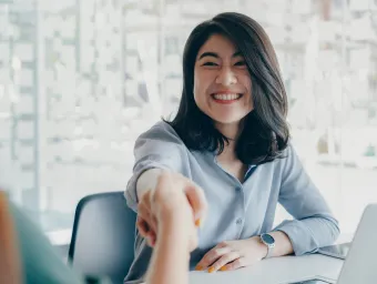 Women shaking hands over a desk