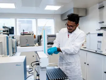 A student conducting an experiment at a test bench in a laboratory