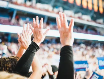 Audience members with their hands up at an American political rally