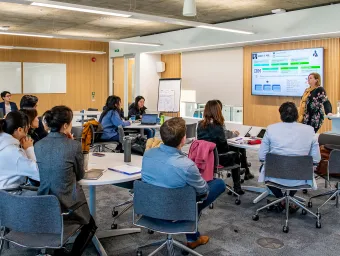 A guest speaker presents to MBA students in a seminar room.
