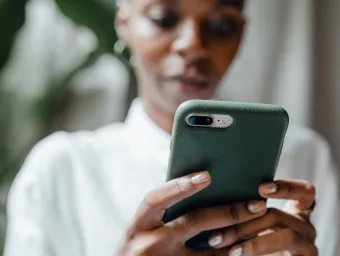 Pexels image of a person clasping a mobile phone intently looking at screen