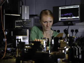 Professor Anna Peacock at work surrounded by equipment in the photonics lab
