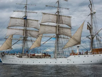White three masts ship sailing near the shore