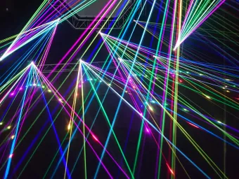 Colourful laser beams intersecting against a dark background.