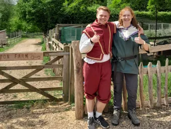 Krzysztof and Joanna standing next to a gate wearing medieval costume