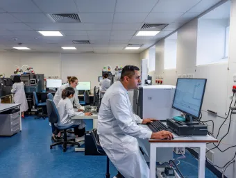 A modern laboratory with scientists working at computers and scientific equipment.