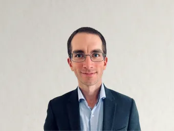 Matthew Blunt, looking directly at the camera in a navy suit with a light blue shirt.