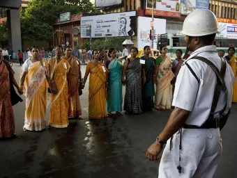 Women standing arm in arm, confronting police