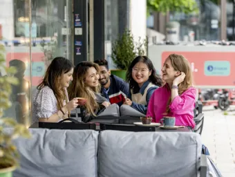 University of Southampton students chatting and socialising together at an outdoor café table.