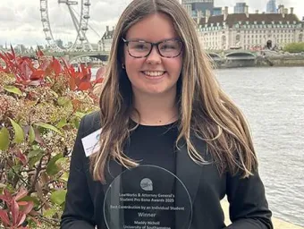 Maddy Nicholl holding Attorney General Pro Bono Award