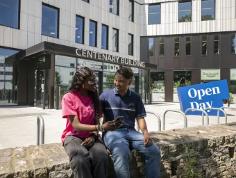 Two students sat outside the Centenary Building on Highfield campus.