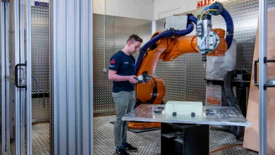 A student uses the robot arm in the engineering design and manufacturing centre