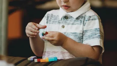 A child is absorbed in playing with brightly coloured building bricks