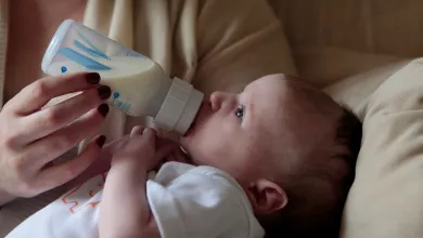 A mother feeds her baby from a bottle