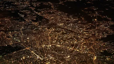 Satellite image of a city showing nighttime activity highlighted by the lights along transport corridors and at points in the city