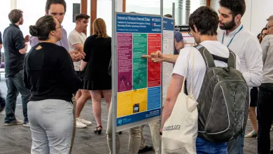 Researchers discussing an academic poster at an event