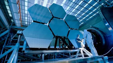A technician testing hexagonal solar panels for a satellite