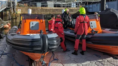 Course instructor and participants looking at 2 powerboats